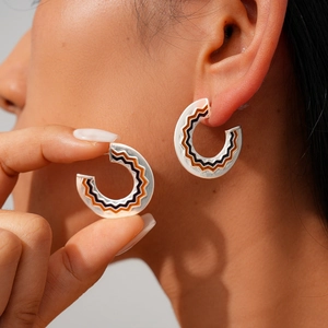 Minimalist silver C-shaped hoop earrings with brown and black wavy enamel patterns