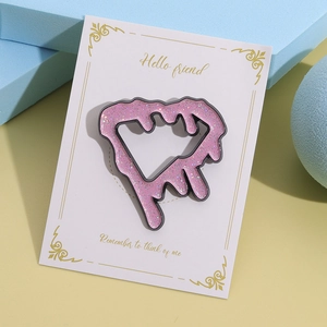 Cute pink glitter hollow geometric brooch on a white gift card with artistic props