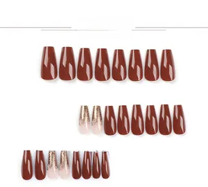 Detail view of long coffin press-on nails in dark reddish brown and gold glitter gradient