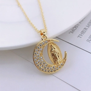 Detailed macro of golden crescent moon pendant with Virgin Mary relief and zircon stones