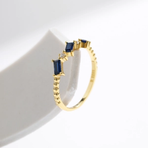 S925 silver wavy ring with emerald-cut blue gemstones and crystal accents on a white stand
