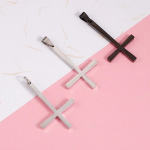 Detailed close-up of polished stainless steel cross pendants in black, silver, and gold