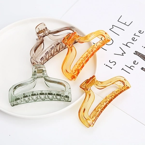 Detail showing colorful transparent acrylic hair claws with metal springs in various shades