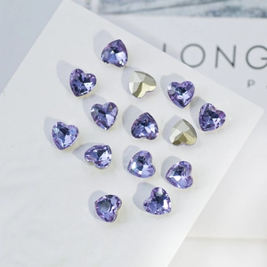 Macro shot of K9 crystal heart-shaped purple nail art rhinestones with sharp facets