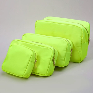 Detailed set of four neon yellow nylon makeup bags with durable gold zippers