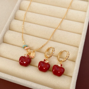 Dettaglio del set ciondolo mela rossa con catena d'oro e orecchini coordinati