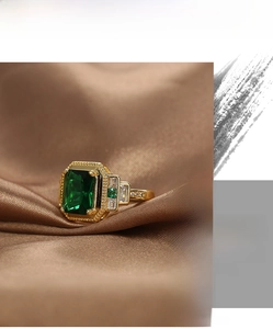 Macro shot of vintage gold ring with emerald-cut green zircon and beaded edge details