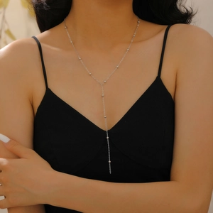 Close-up of a double-layered Y-shaped necklace with silver beads on a model wearing black