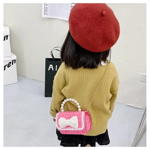 Pink tweed crossbody bag for kids featuring a large pearl bow and elegant gold chain