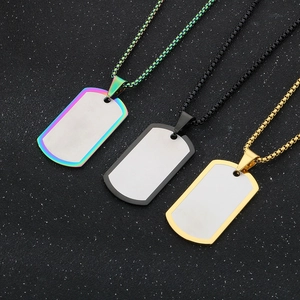 Gros plan de pendentifs plaques militaires en acier or, noir et arc-en-ciel sur une chaîne