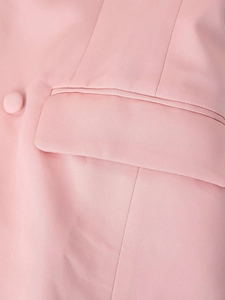 Detail of pink blazer featuring pocket flap tailoring and twill woven fabric texture