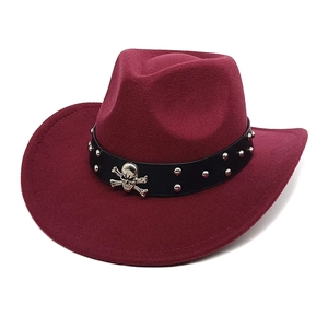 Détail du chapeau de cowboy bordeaux avec ruban en cuir, clous et ornement de crâne