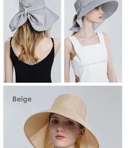 Detail view of beige and grey sun hats with large brim, neck protection and bow