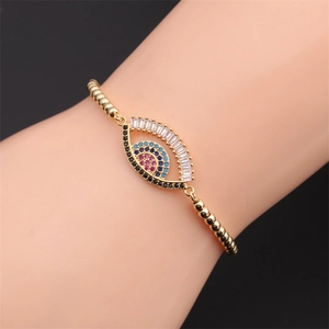 Detailed macro view of gold evil eye bracelet with colorful zircons on a model wrist