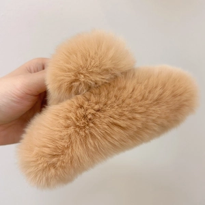 Detailed view of large brown faux fur claw clip with soft texture for winter hairstyles