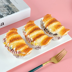 Close-up of realistic croissant sandwich models with ham, cheese and lettuce on a tray