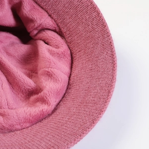 Close-up of pink knitted hat showing thick fleece lining and soft fiber texture