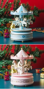 Detail of wooden carousel music boxes in pink and blue with festive Christmas decor