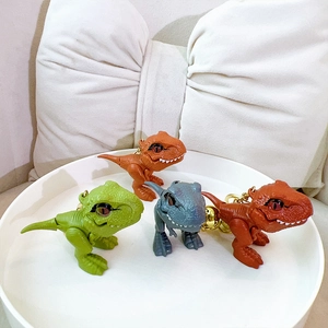 Set of four colorful T-Rex dinosaur keychains in green, grey, orange, and red colors