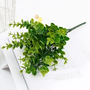 Detail of artificial eucalyptus leaves on an open book for home decor and wedding setting