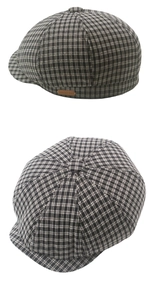 Detail of classic black and white plaid newsboy cap with brown leather decorative side label