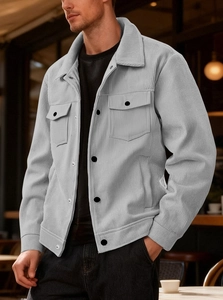 Detail of light gray corduroy jacket showing buttoned chest pockets and striped texture