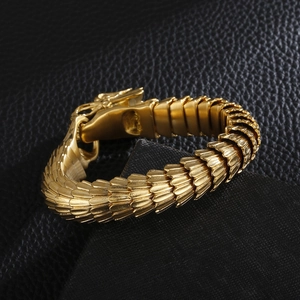 Detailed close-up of golden dragon scale bracelet with intricate cast metal textures