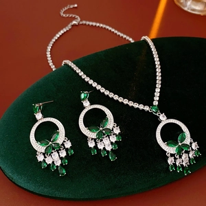 Détail d'un ensemble de bijoux en émeraude et zircon sur un support en velours vert