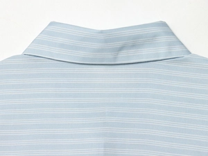 Détail de l'encolure et de la texture du tissu d'une chemise rayée bleu clair