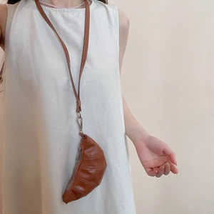 Détail du mini sac croissant en cuir PU marron avec fermeture éclair et bandoulière de cou