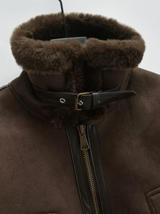 Close-up of brown suede jacket with faux fur collar and leather buckle detail
