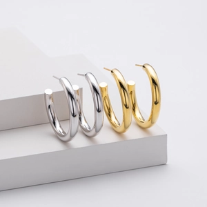 Detailed view of polished S925 sterling silver C-shape hoop earrings in gold and silver