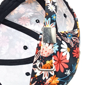 Détail de la boucle métallique réglable et imprimé floral sur casquette de baseball