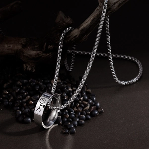 Détail du collier anneau en acier inoxydable argenté avec motif bonhomme sur galets