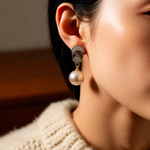Close-up of vintage geometric earrings with sparkling diamonds and round cream pearls