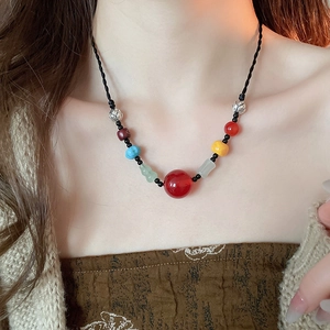 Detailed close-up of a vintage ethnic necklace with colorful resin beads on a black cord