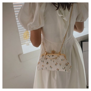 Close-up of vintage shell bag with yellow roses embroidery and pearl handle detail