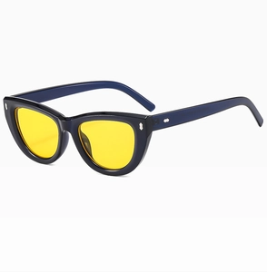 Dettaglio occhiali da sole cat-eye con lenti gialle e montatura blu scuro con borchie