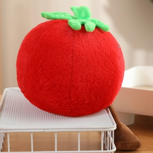 Close-up of a cute plush red tomato toy with green leaves and brown legs on a shelf