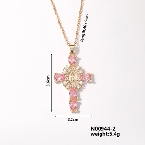 Detail of vintage gold cross pendant with pink zircons and Virgin Mary relief carving