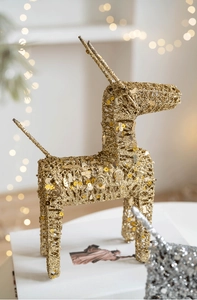 Close-up of golden iron Christmas reindeer decor with sequins and warm bokeh background