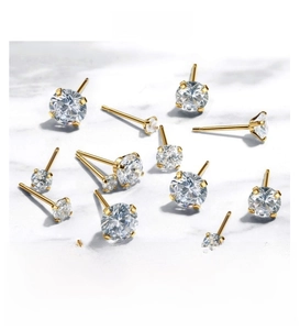 Detailed close-up of golden titanium steel ear studs with sparkling cubic zirconia settings