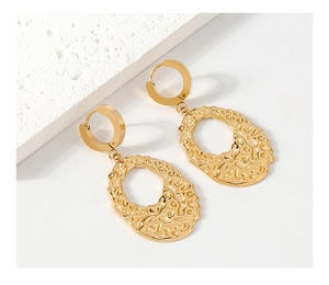 Detailed macro view of irregular gold hollow earrings with a polished metallic finish