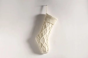 Close-up of cream knit Christmas stocking with diamond pattern and hanging loop