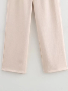 Detailed macro view of light pink casual trousers showing cotton linen fabric texture