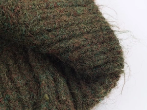 Detailed macro shot of dark green mohair blend knit fabric showing rich texture and fibers