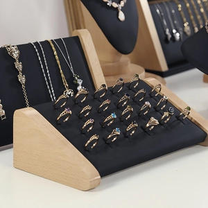 Makroaufnahme von Holzschmuckständer mit schwarzem Polster für Ringe und Halsketten