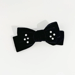 Detailed view of the velvet texture and faux pearl embellishments on the vintage bow clip