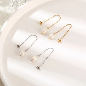 Detailed view of elegant gold and silver chain earrings with natural baroque pearls