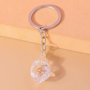 Detail of silver conch keychain with real shell inside transparent resin pendant